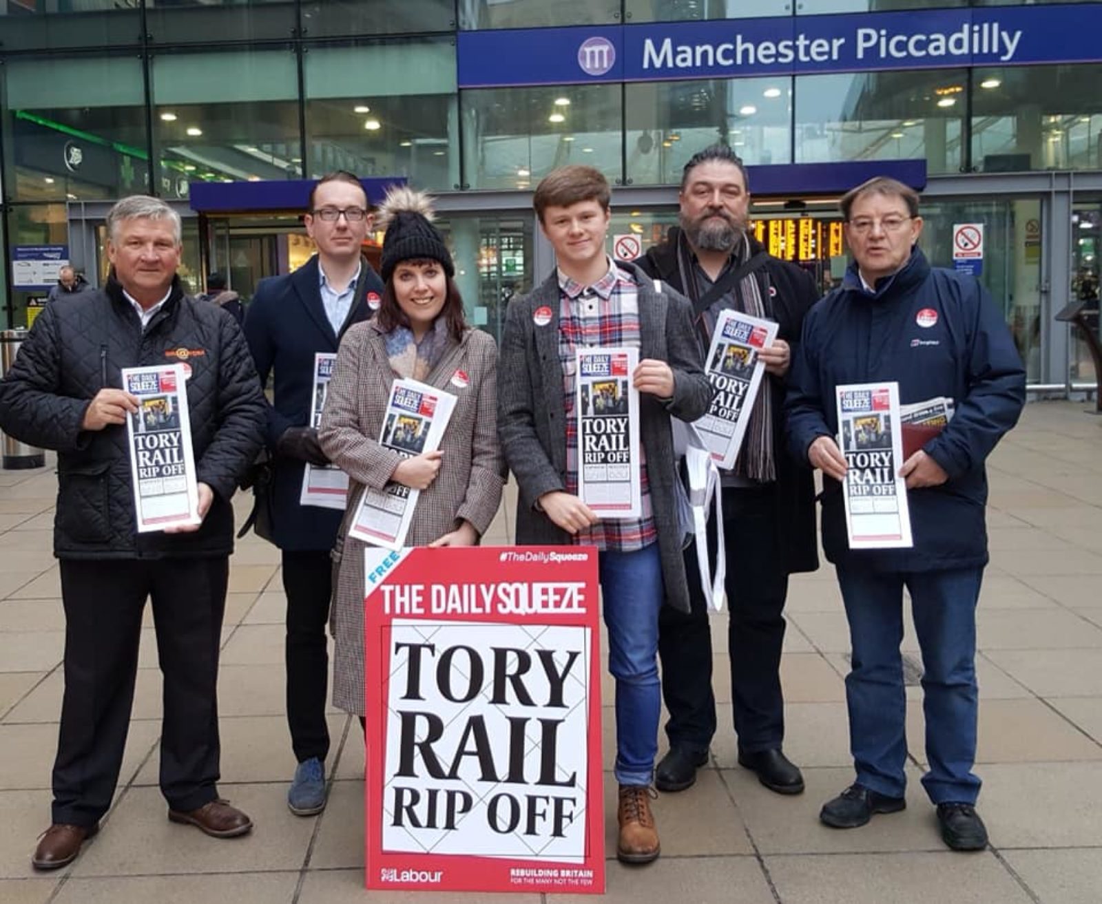 Members of Manchester Central Labour outside Piccadilly station highlighting the "Daily Squeeze" driven by the Tory Rail Rip Off